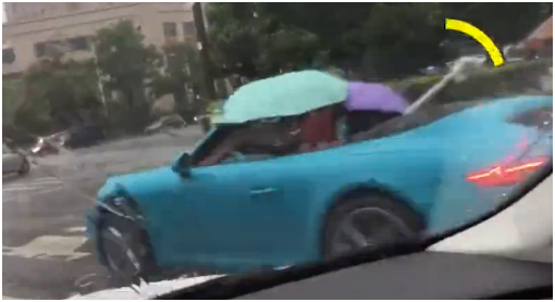 敞篷跑車打（dǎ）傘前行